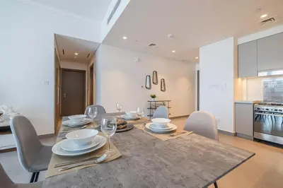 a dining room with a table and chairs and a kitchen at Spacious 2BDR in Creek Harbor with City View in Dubai