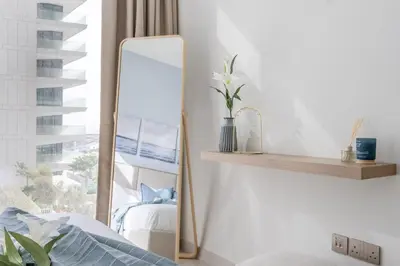 a mirror sitting on a shelf next to a bed at GuestReady - Sea View Escape In Marina in Dubai