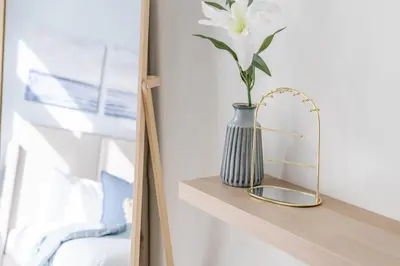 a vase with a flower on a shelf with a mirror at GuestReady - Sea View Escape In Marina in Dubai