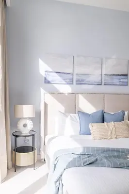 a white bedroom with a bed with blue pillows at GuestReady - Sea View Escape In Marina in Dubai