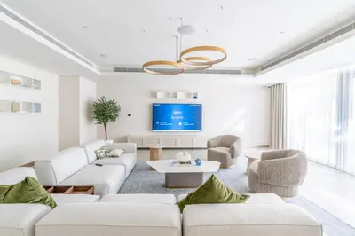 a living room with white furniture and a flat screen tv at GuestReady - Sea View Escape In Marina in Dubai