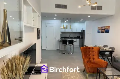 a living room and kitchen with a table and chairs at Birchfort - Newly renovated unique 1 bedroom apartment in Dubai