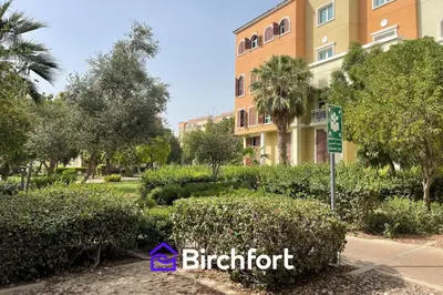 a building with a sign in front of a park at Birchfort - Newly renovated unique 1 bedroom apartment in Dubai