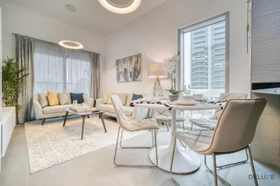 a living room with a table and chairs at Refined 1BR at Bella Rose Barsha South by Deluxe Holiday Homes in Dubai