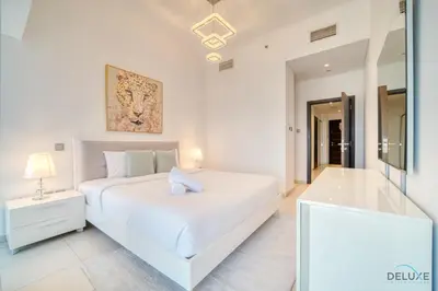 a white bedroom with a white bed and a mirror at Sea Views from Living to Bedroom Perfect for Staycation, Dubai Marina by Deluxe Holiday Homes in Dubai