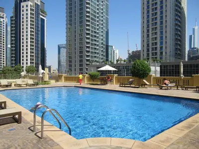 a large swimming pool in a city with tall buildings at La Buena Vida Holiday Homes - Beach front very spacious, luxe and modern 3 bedroom with full kitchen in JBR , 3 min to the JBR beach Dubai Marina and Tram Station in Dubai