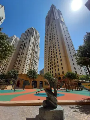 a statue in a park with two tall buildings at La Buena Vida Holiday Homes - Beach front very spacious, luxe and modern 3 bedroom with full kitchen in JBR , 3 min to the JBR beach Dubai Marina and Tram Station in Dubai