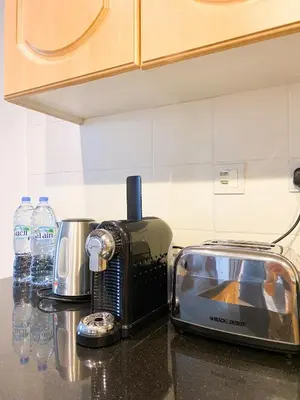 a toaster sitting on a counter in a kitchen at La Buena Vida Holiday Homes - Exquisite Spacious Luxe 1BR Apt , Full Marina View, Kitchen, 5 Min to Beach, JBR and Marina in Dubai