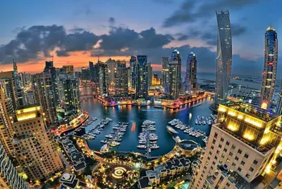 a city at night with boats in a harbor at La Buena Vida Holiday Homes - Exquisite Spacious Luxe 1BR Apt , Full Marina View, Kitchen, 5 Min to Beach, JBR and Marina in Dubai