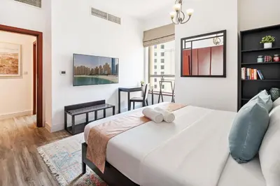 a bedroom with a large white bed in a room at La Buena Vida Holiday Homes - Modern, Luxe & Spacious 4-Bed, Full Kitchen, near to Beach, Tram & Marina in Dubai