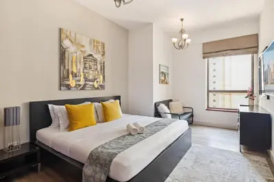 a bedroom with a large bed with yellow pillows at La Buena Vida Holiday Homes - Modern, Luxe & Spacious 4-Bed, Full Kitchen, near to Beach, Tram & Marina in Dubai