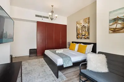 a bedroom with a large bed and a couch at La Buena Vida Holiday Homes - Modern, Luxe & Spacious 4-Bed, Full Kitchen, near to Beach, Tram & Marina in Dubai