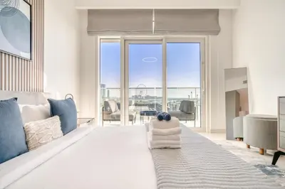 a bedroom with a bed with a view of the ocean at Emaar Beach Front 2BR with Sea & Marina Skyline Views in Dubai