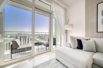 a living room with a couch and a large window at Emaar Beach Front 2BR with Sea & Marina Skyline Views in Dubai