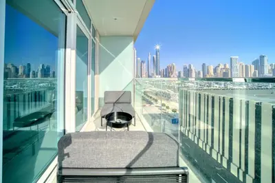a chair in a room with a view of a city at Emaar Beach Front 2BR with Sea & Marina Skyline Views in Dubai