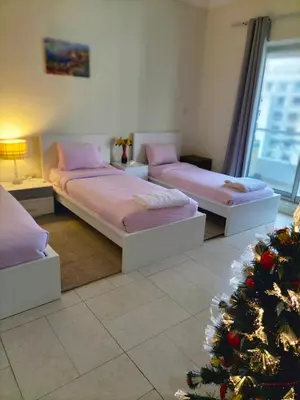 two beds in a room with a christmas tree at Amazing apartment 2 bed rooms in Tecom 6 pax in Dubai
