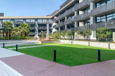 a large building with a lawn in front of it at Frank Porter - Belgravia 3 in Dubai