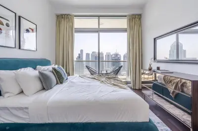 a bedroom with a large bed and a large window at GuestReady - Skyview Home with Marina View in Dubai