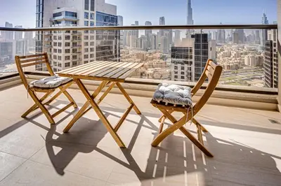 a wooden table and two chairs on a balcony at Amazing Burj Khalifa view from Brand new apartment in Dubai