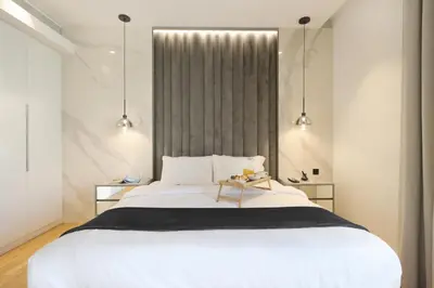 a bedroom with a large white bed and two lights at Livbnb-Upgraded 2BR plus Maid's Room with Sea View in Dubai