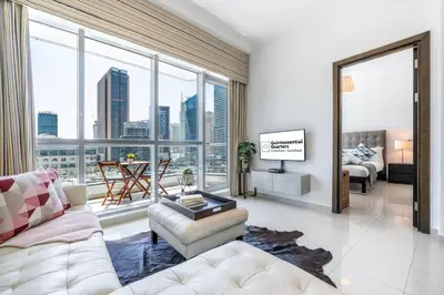 a living room with a white couch and large windows at Cute 1BR - Dubai Marina Views - Walk 9min to Beach in Dubai