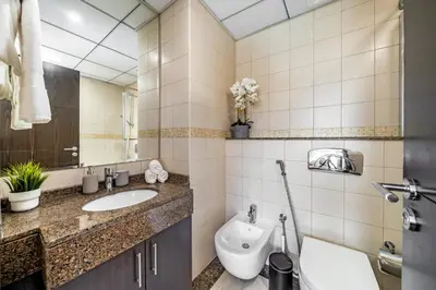 a bathroom with a sink and a toilet and a mirror at Cute 1BR - Dubai Marina Views - Walk 9min to Beach in Dubai