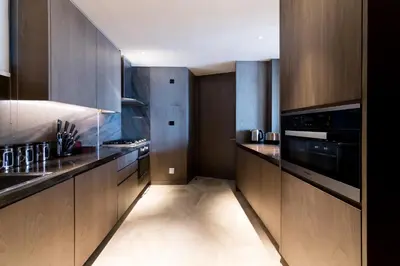 a kitchen with wooden cabinets and black appliances at Maison Privee - Luxury Sea View Apt in FIVE Resort on The Palm in Dubai