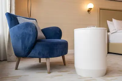 a blue chair and a white trash can in a room at Palm Tower where Luxury & View meet in one place in Dubai