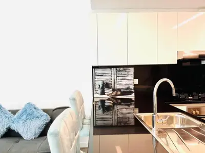 a living room with a couch and a kitchen with a sink at ModernLux - Lovely Studio Apartment in JVT next to Park in Dubai
