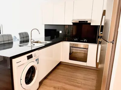 a kitchen with a washer and a sink and a refrigerator at ModernLux - Lovely Studio Apartment in JVT next to Park in Dubai