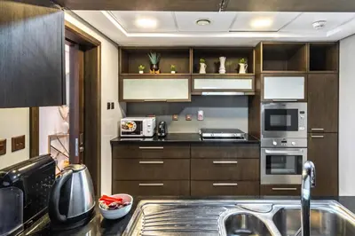 a kitchen with wooden cabinets and a sink at The Lofts - Luxurious space with Burj Khalifa View in Dubai