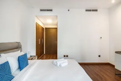 a bedroom with a large bed with blue and white pillows at The Lofts - Luxurious space with Burj Khalifa View in Dubai