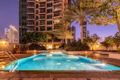 a swimming pool in the middle of a city at night at The Lofts - Luxurious space with Burj Khalifa View in Dubai