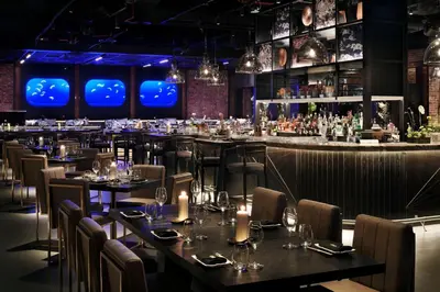 a restaurant with tables and chairs and a bar at Marriott Resort Palm Jumeirah, Dubai in Dubai