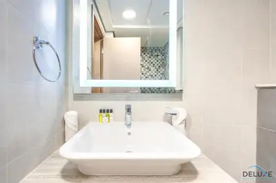 a white sink in a bathroom with a mirror at Perfect Studio Getaway Next to the Iconic Creek Harbour, Azizi Aliyah, Al Jaddaf, by Deluxe Holiday Homes in Dubai