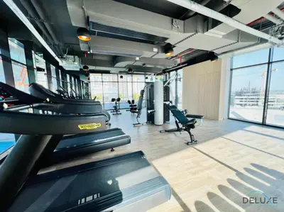 a gym with treadmills and chairs in a building at Homely 1BR at Binghatti Avenue Al Jaddaf by Deluxe Holiday Homes in Dubai