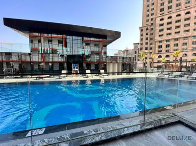 a large swimming pool in front of a building at Homely 1BR at Binghatti Avenue Al Jaddaf by Deluxe Holiday Homes in Dubai