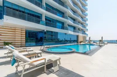 a swimming pool in front of a building at GlobalStay Business Bay Waves Tower Apartments Dubai in Dubai