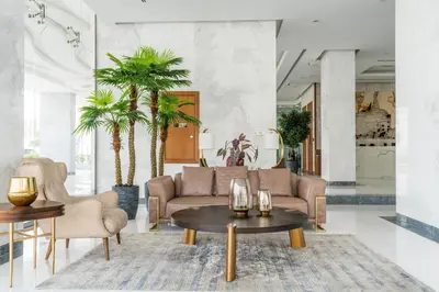 a living room with a couch and tables and palm trees at GlobalStay Business Bay Waves Tower Apartments Dubai in Dubai