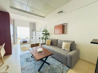a living room with a couch and a table at LV13 - Elegant Studio in Lake View Tower in Dubai