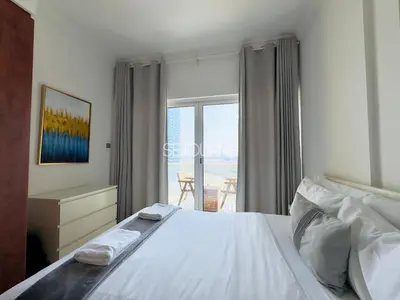 a bedroom with a bed and a window with a view at LV13 - Elegant Studio in Lake View Tower in Dubai