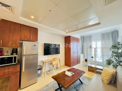 a kitchen and living room with a refrigerator and a table at LV13 - Elegant Studio in Lake View Tower in Dubai