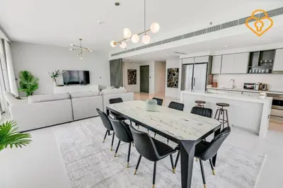 a dining room and living room with a table and chairs at Fascinating Views! Large 4BR Private Beach Access, Emaar BeachFront in Dubai