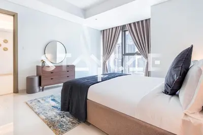 a white bedroom with a large bed and a mirror at Staycae Holiday Homes - Paramount Midtown in Dubai
