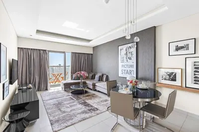 a living room with a couch and a table at ALiving Elegant 1BR I Burj Khalifa View I Paramount Towers- 6103 in Dubai