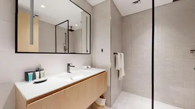 a bathroom with a sink and a mirror and a shower at Stylish Studio with Burj Khalifa View in Dubai