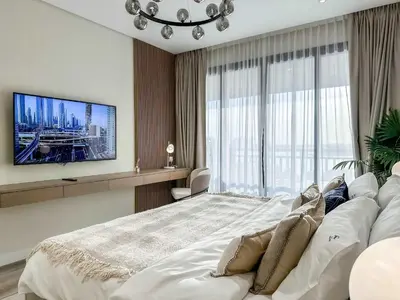 a bedroom with a large bed and a tv at Fabulous 1 bedroom apartment at 5 Star Resort in Dubai
