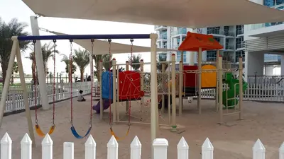 a playground with a swing in a city at DUBAI - Glitz 3 Residences - MAJESTIC Luxe Holiday Home - 2BR - Sleep 4 - FOR FAMILIES & COUPLES STAYS ONLY in Dubai