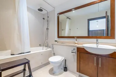 a bathroom with a sink and a toilet and a mirror at GuestReady - Upscale Modern Apt in Downtown in Dubai