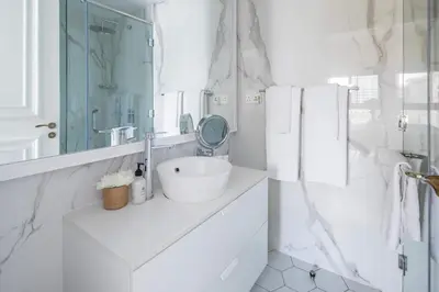 a white bathroom with a sink and a mirror at Frank Porter - Fairmont Residence South in Dubai
